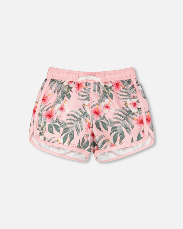 Front flat lay of Deux par Deux girl pink hibiscus girls swim shorts with curved hem
