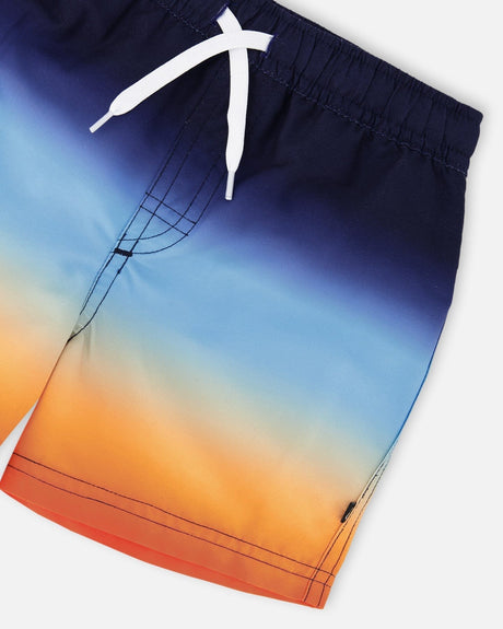 Close-up of waistband, drawstring, and gradient fabric on blue/orange boys swim trunks