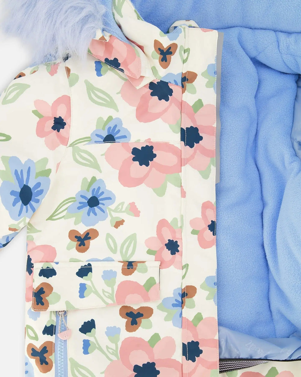 Closeup of printed jacket and navy pant waist showing fleece lining and stitching.