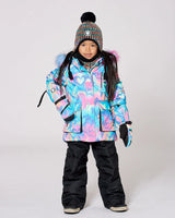 Model wearing multicolor jacket and snow pants, detachable hood, breathable shell.