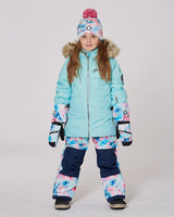 Model wearing Blue Flower jacket and snow pants, detachable hood and snow skirt.