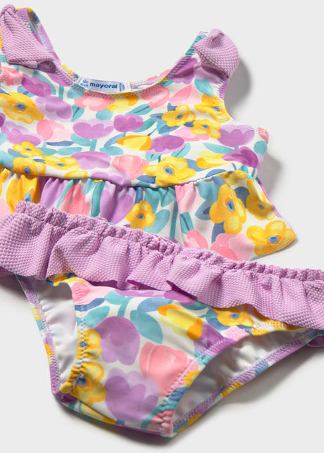 Closeup of Mayoral baby girl swim set showing Lilac ruffle trim, floral print, and stretch fabric.