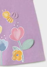 Closeup of floral and bee-inspired screen print on Lilac baby graphic dress.