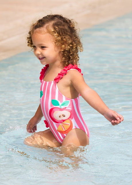Baby girl wearing Mayoral Pink graphic swimsuit for pool and summer water play.