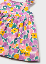 Closeup of Mayoral floral baby dress showing colorful print, gathered waist, and cotton stretch texture.