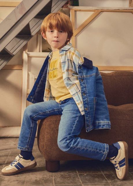 Child wearing the medium wash Mayoral jeans, seated
