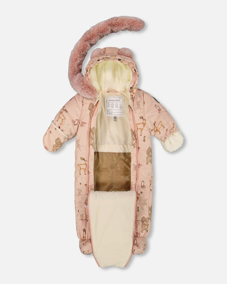 Lifestyle photo of a baby wearing the pink animal print car seat–compatible snowsuit
