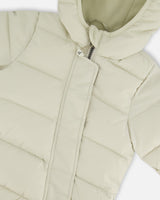 Close-up PrimaLoft quilting of off-white baby snowsuit