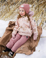 Toddler wearing Deux par Deux Baby Snug snowsuit in dusty pink