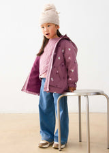 Girl wearing Mayoral Mauve heart print raincoat with hood for school and rainy-day outings.