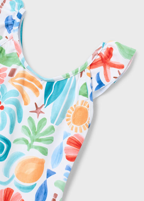 Closeup of Mayoral girls swimsuit showing ruffled shoulder detail, stretchy fabric, and multicolor print.