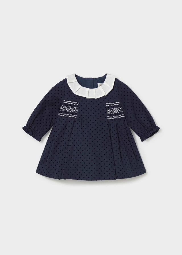 Mayoral baby girl navy polka dot dress with pleated ivory collar and white smocking, front view