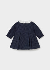 Back view of the navy polka dot dress with back zipper and pleated skirt