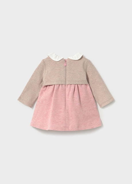 Back view of the powder pink and beige baby dress with a zip and ruffled collar