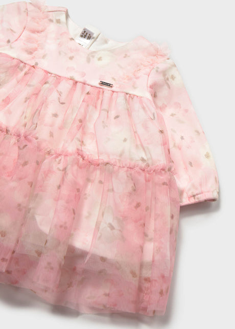 Close-up of the pink floral tulle tiers and shoulder ruffle on the baby dress