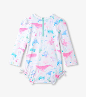 Back view of baby girl one-piece swim suit showing zipper closure and pastel sealife print.